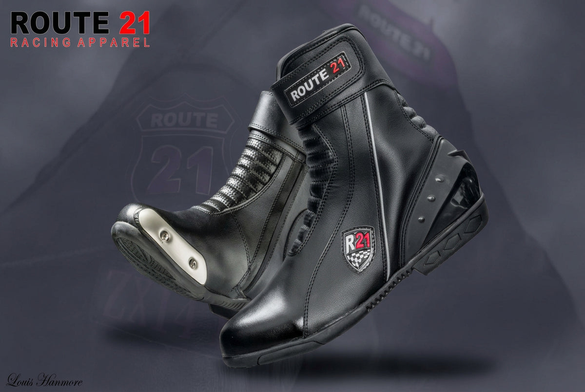 A pair of black leather Route 21 Racing Apparel motorcycle boots with silver metallic toe guards and Route 21 branding, shown against a dark purple graphic background.